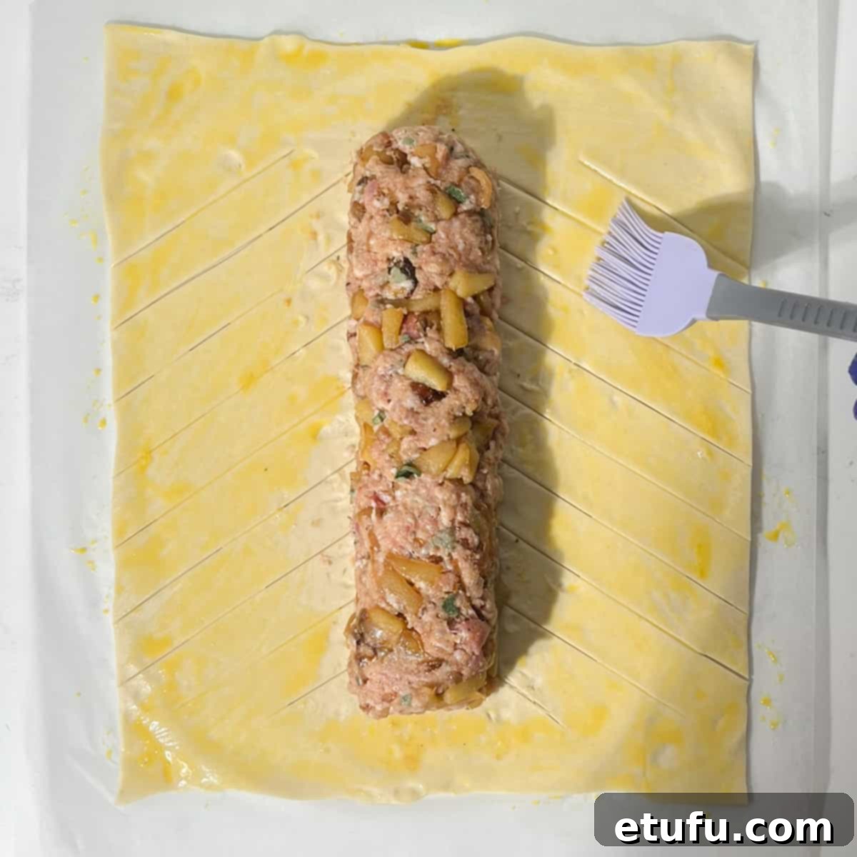 Brushing the puff pastry with egg wash.