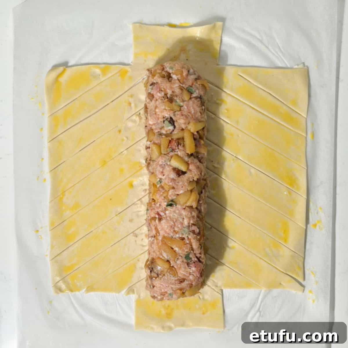 Trimming the ends of the puff pastry for the sausage meat plait.
