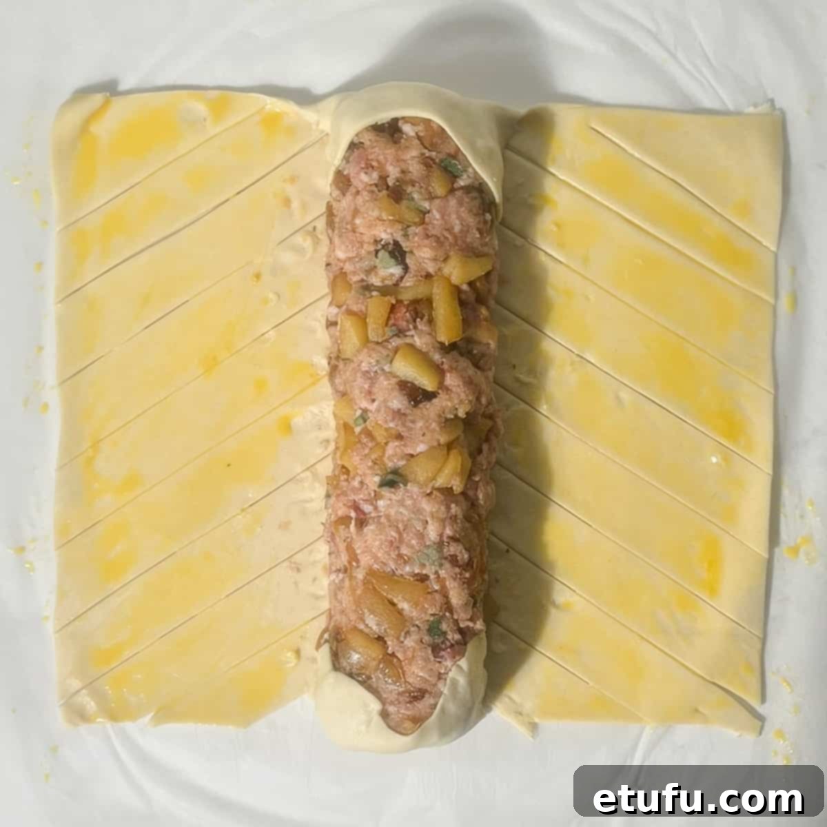 Sealing the ends of the giant sausage roll with the pastry.