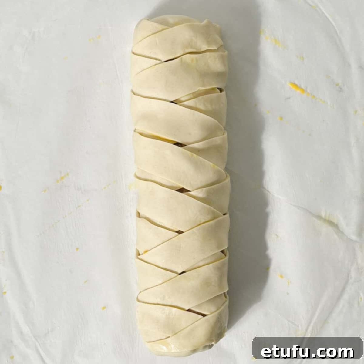 A fully plaited, unbaked sausage roll.