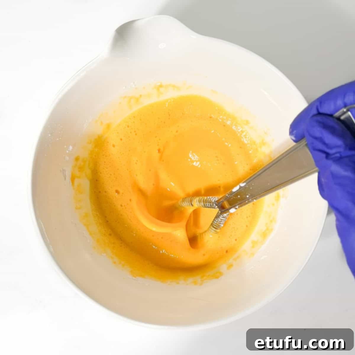 Vigorously whisking the egg and dry ingredient mixture until smooth.