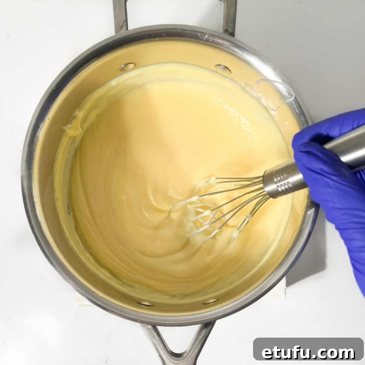 Whisking the milk tart filling until it thickens and leaves trails.