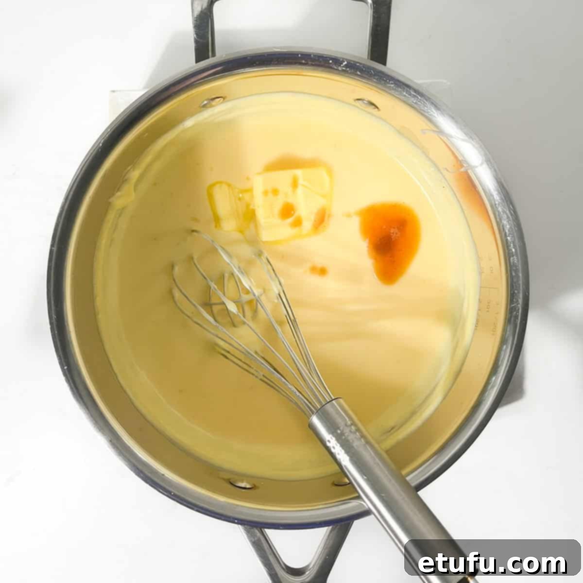 Adding butter and vanilla extract to the finished milk tart filling.