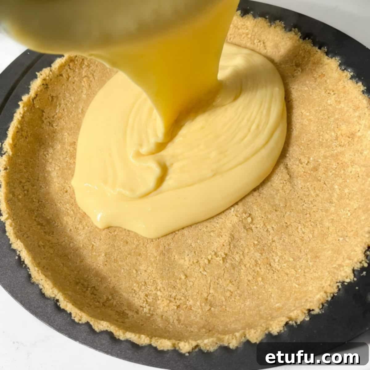 Pouring the creamy milk tart filling into the biscuit crust.