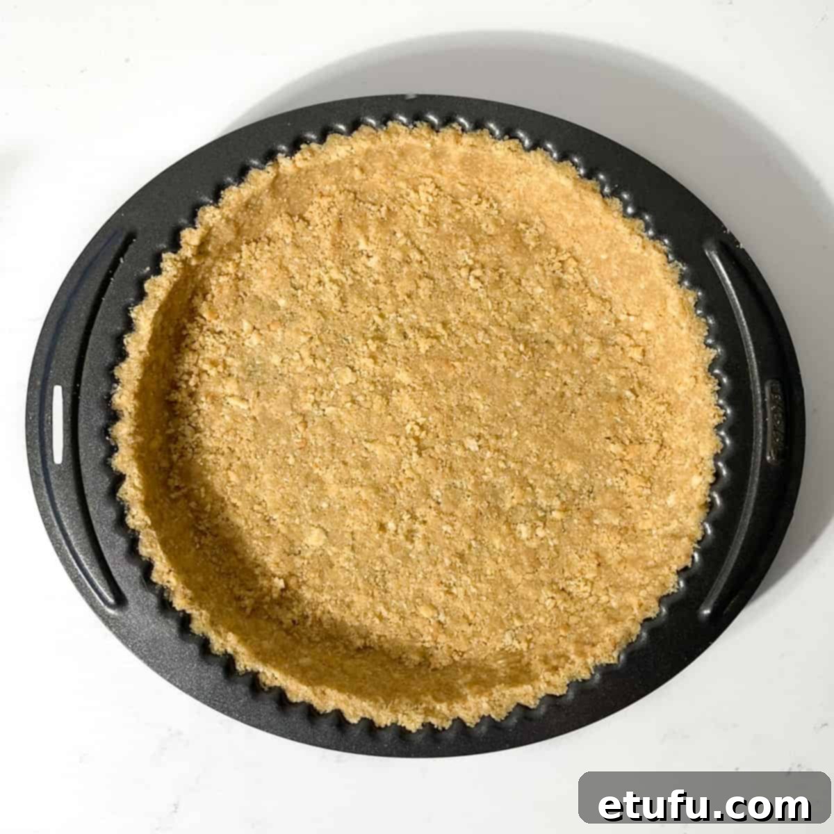The finished biscuit crust pressed into a tart tin, ready for chilling.