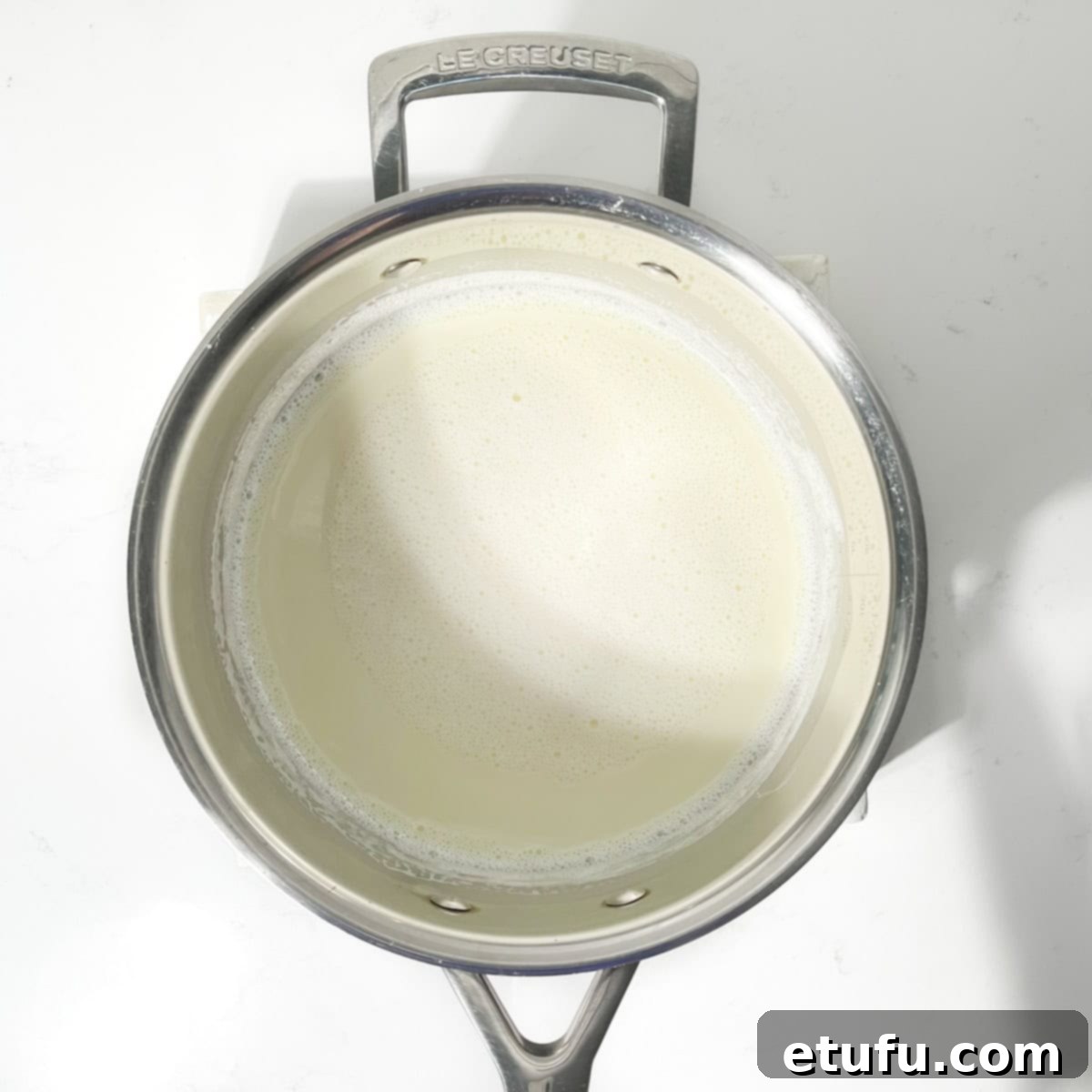 Boiled milk and condensed milk in a large saucepan, gently simmering.