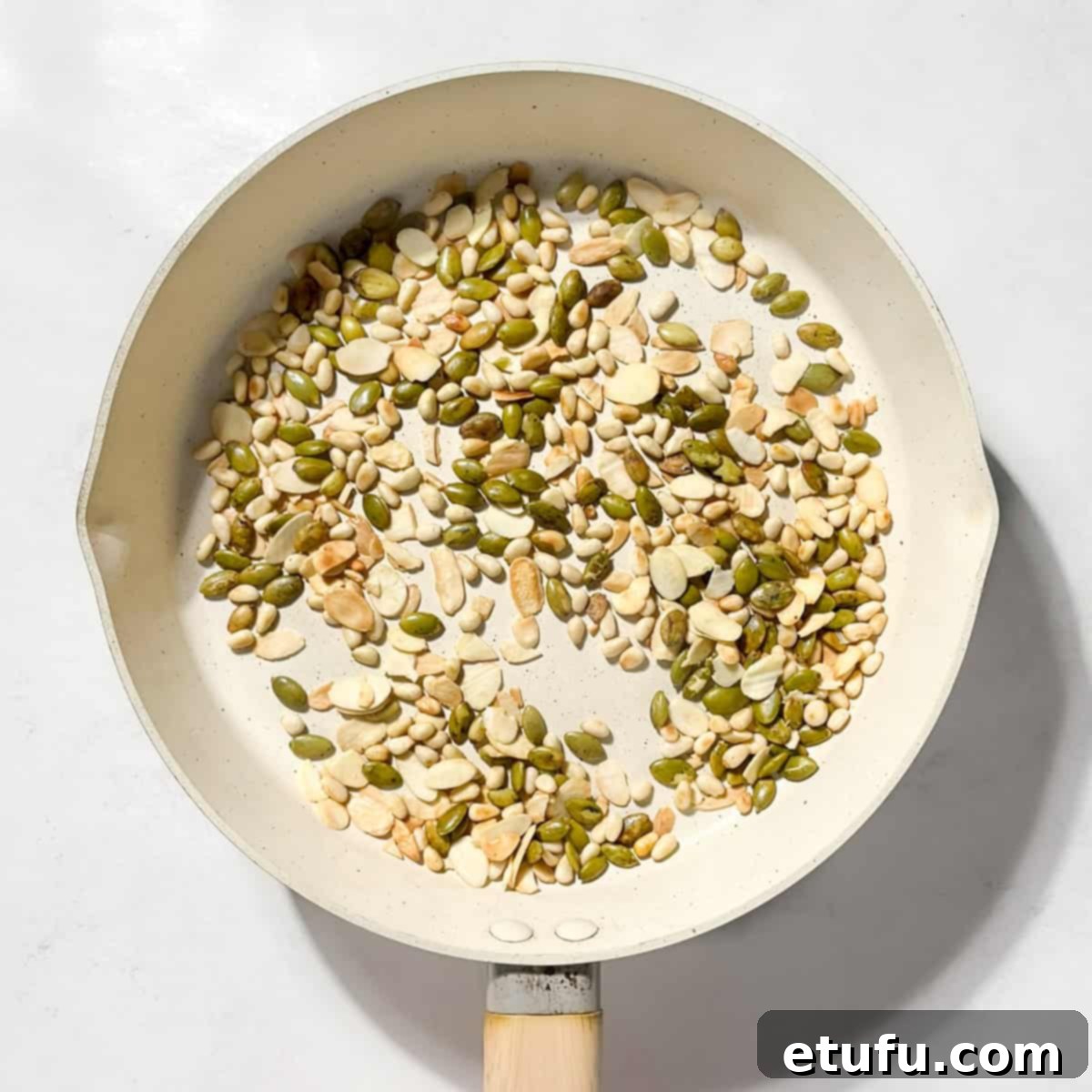 Toasting all the seeds in a large frying pan.
