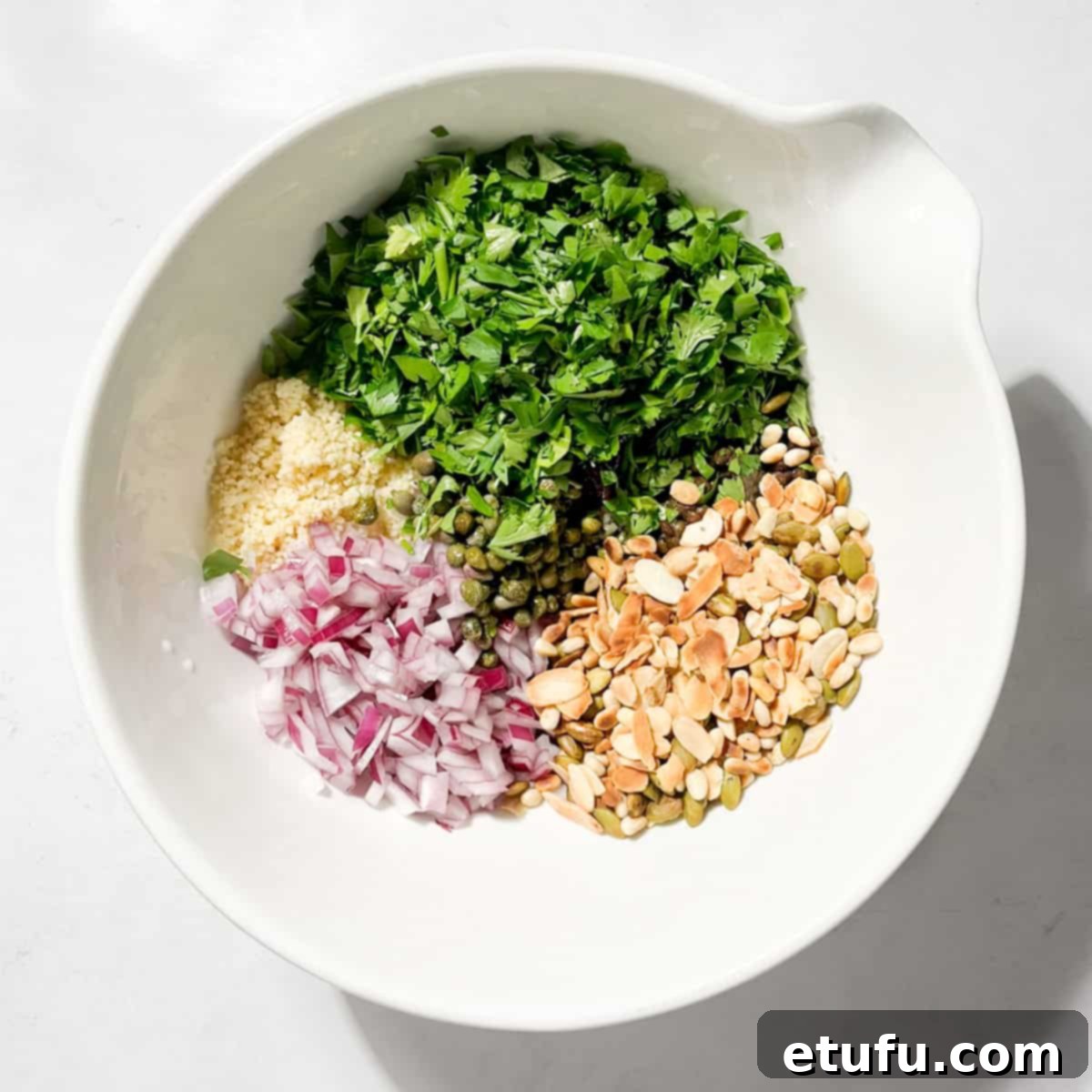 All the ingredients for the Cypriot grain salad in a large white bowl.