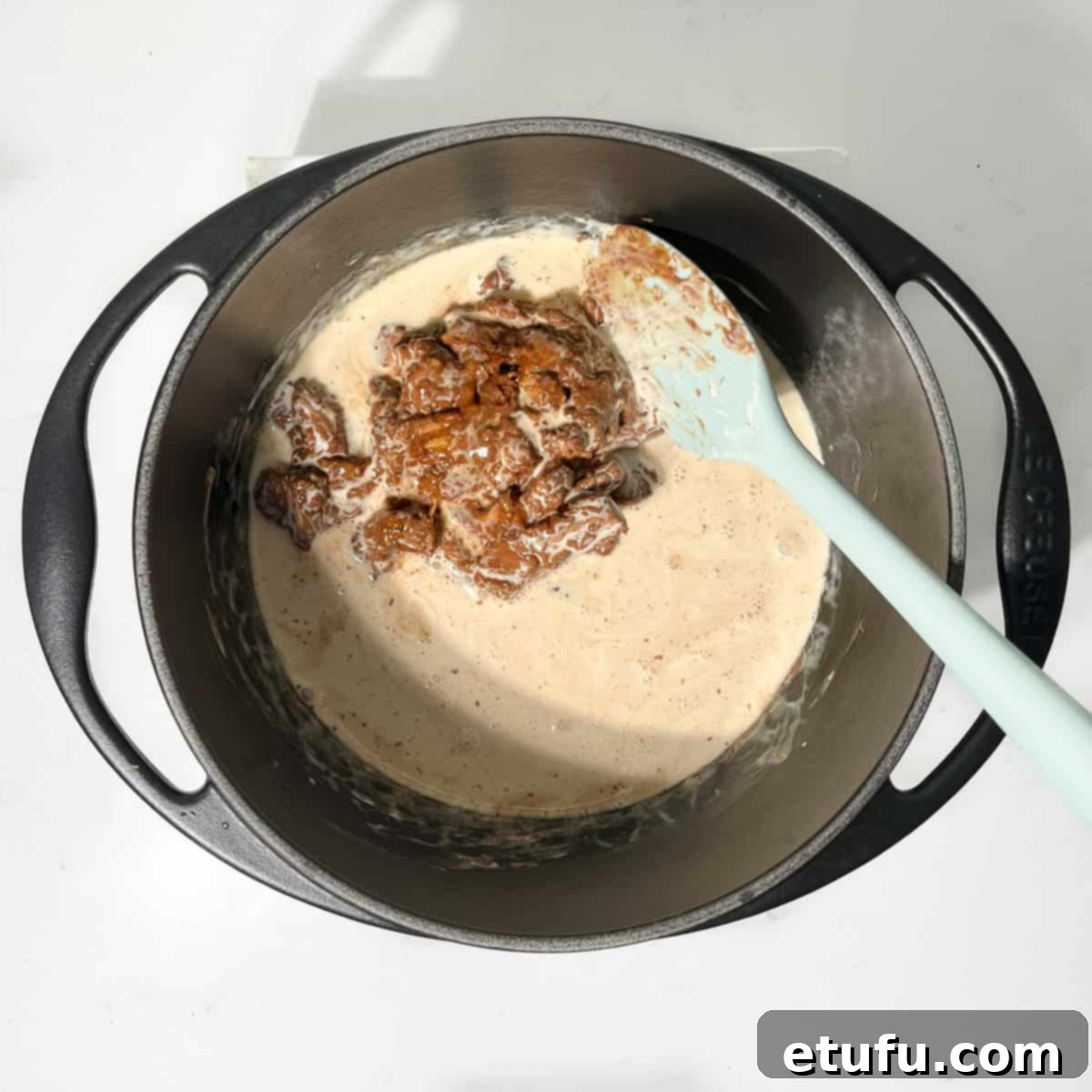 Gently stirring the nougat chunks into the cream in a small saucepan.