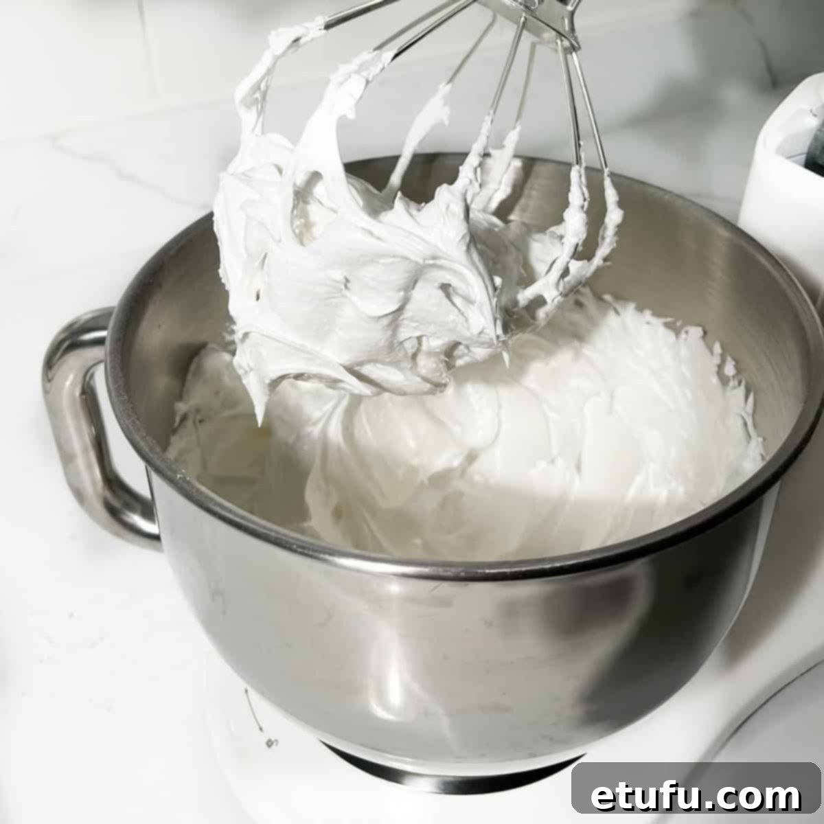 The glossy, stable meringue for the jam and coconut tartlets, perfectly whipped in the stand mixer bowl.