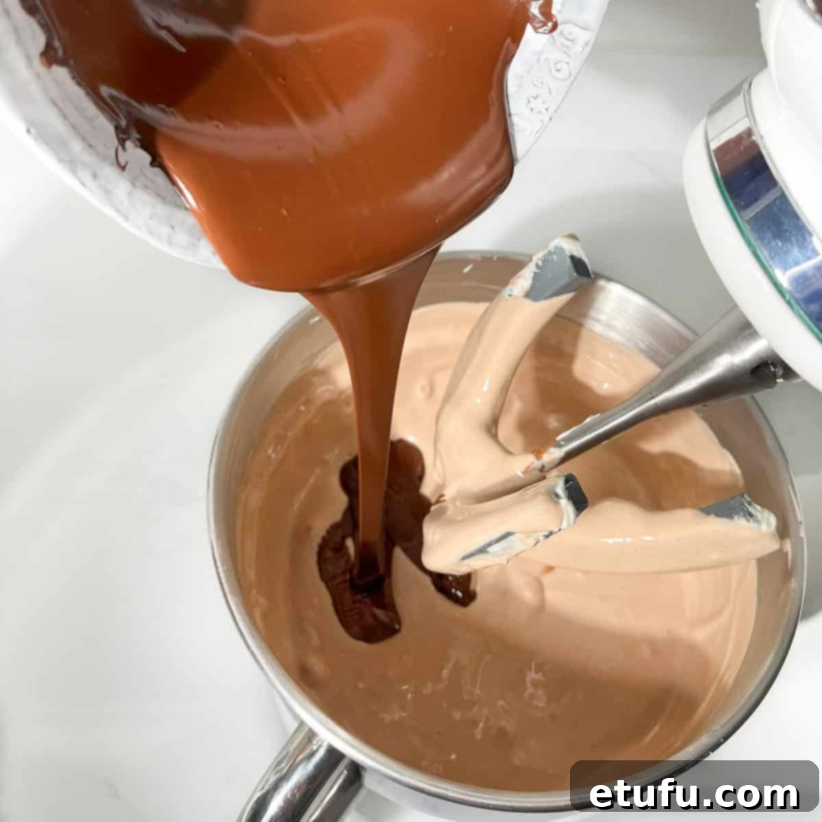 Adding the melted chocolate to the chocolate basque cheesecake mixture.