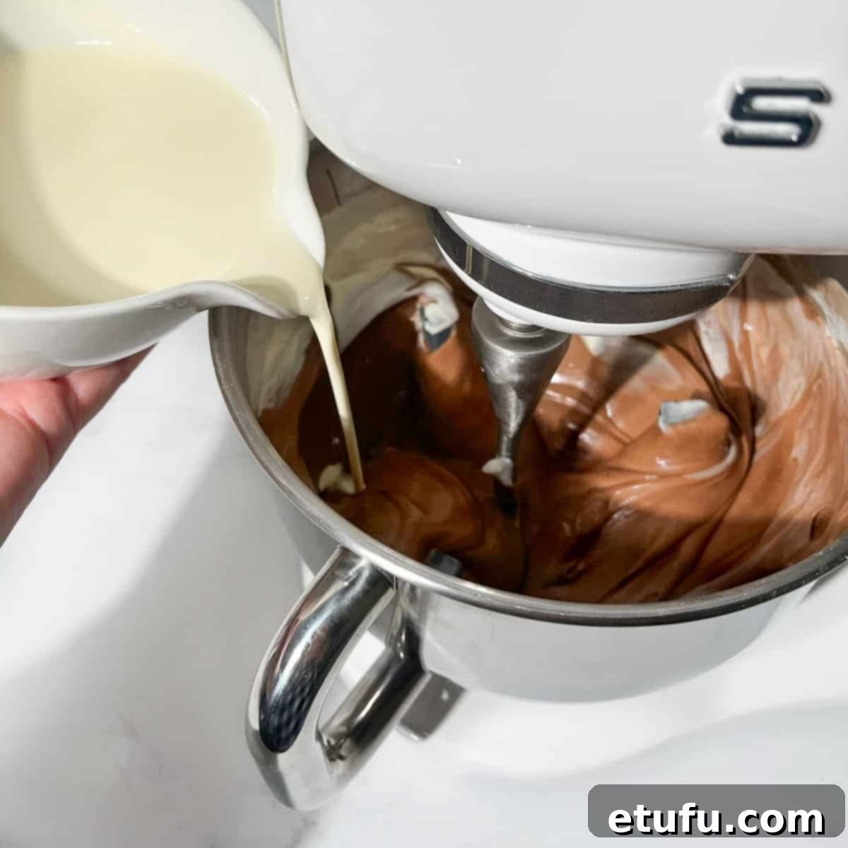 Adding cream to the chocolate cheesecake mixture whilst it's beating in the stand mixer.
