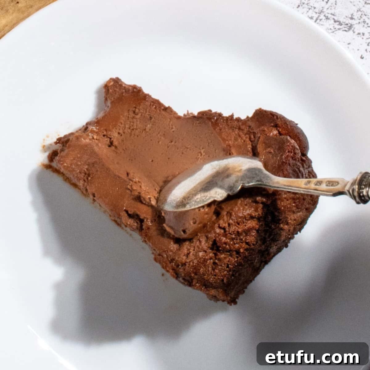 A slice of chocolate basque burnt cheesecake on a white plate.