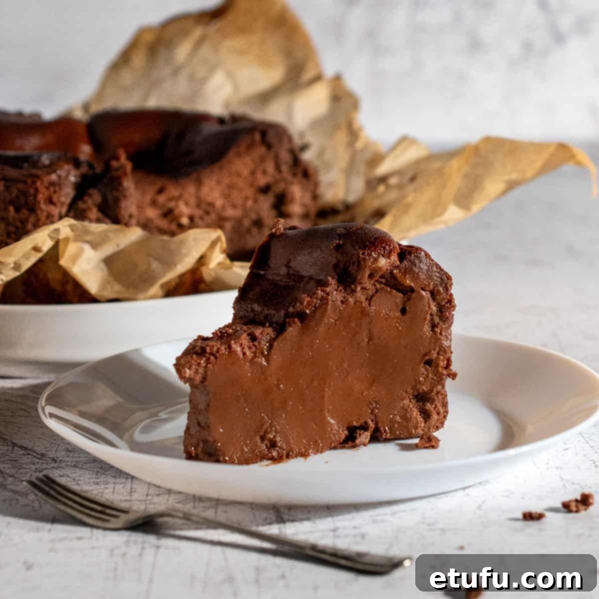 A slice of chocolate basque burnt cheesecake on a white plate.