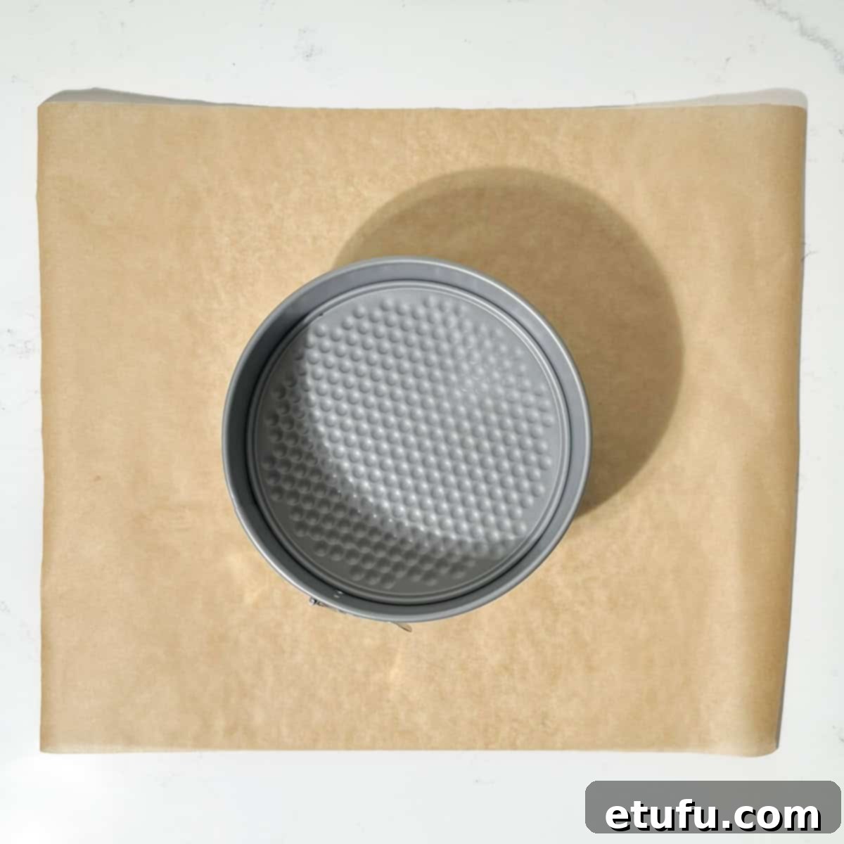 A baking tin on a square of baking paper.
