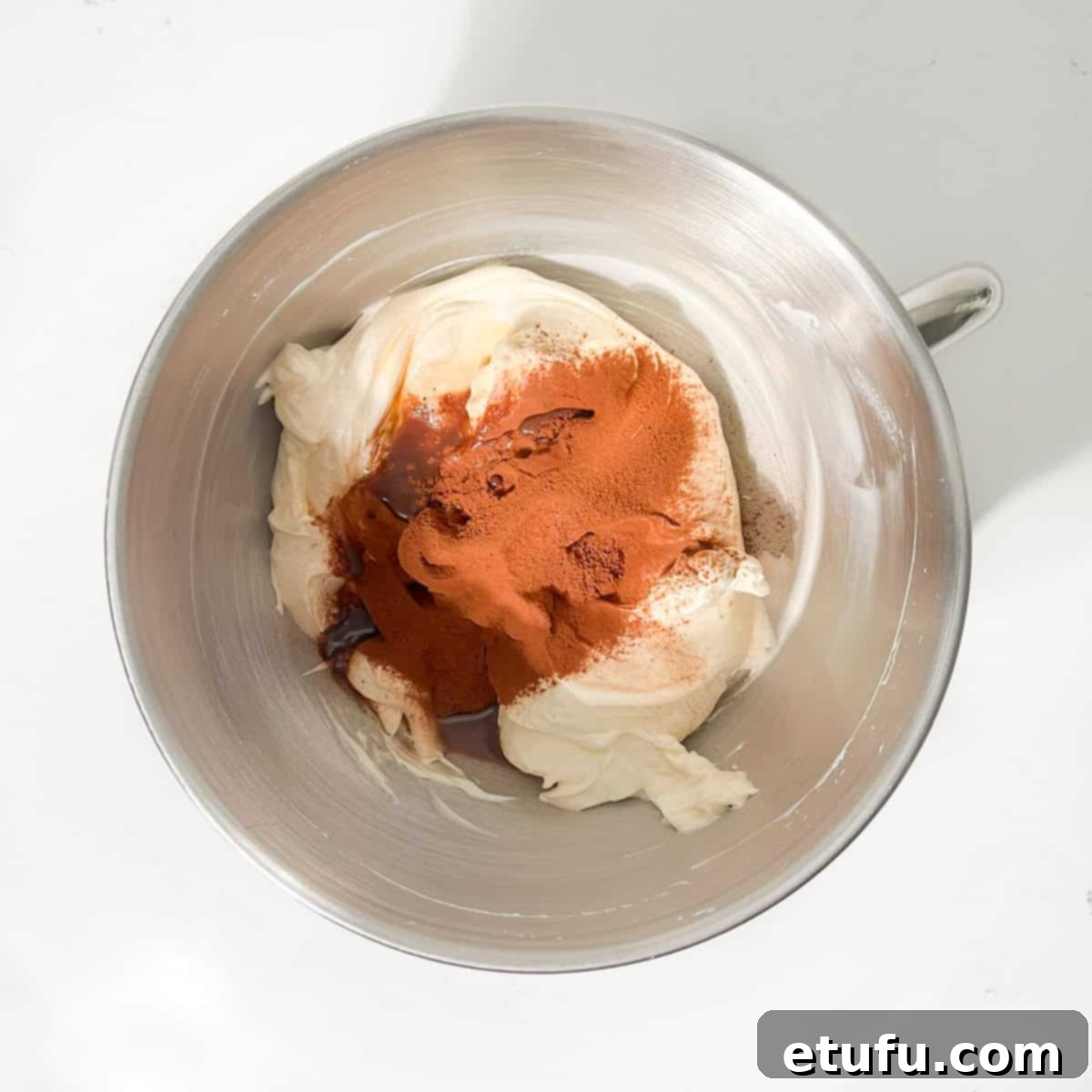 Chocolate basque cheesecake ingredients in the bowl of a stand mixer.