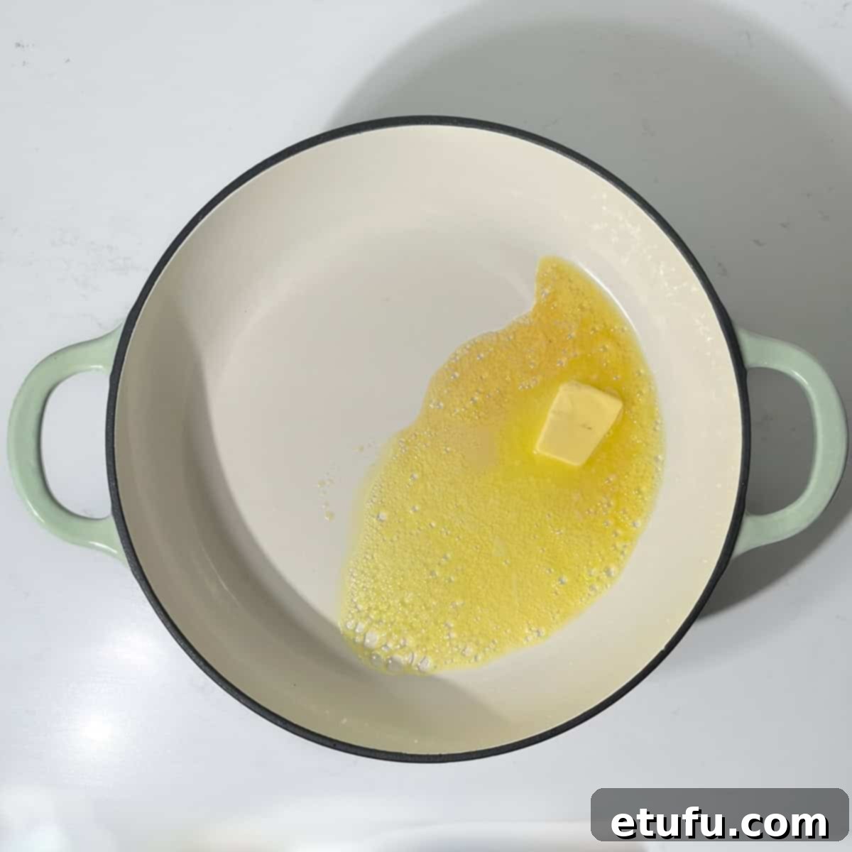 Melting butter and honey in a large saucepan, creating a sizzling mixture.