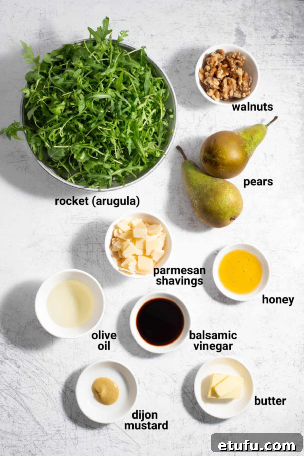 Ingredients for pear and rocket salad laid out on a table.