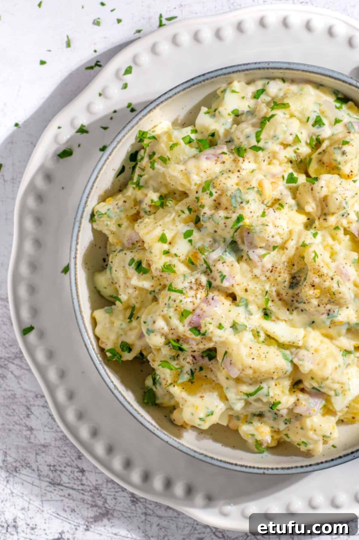 South African potato salad with condensed milk on a white bowl.