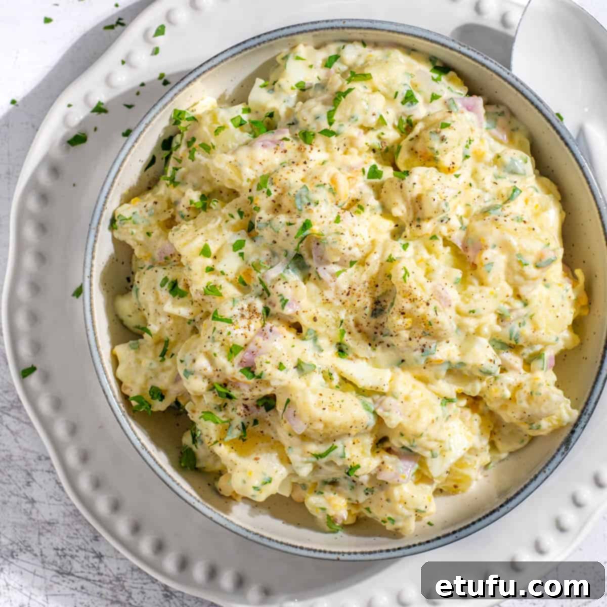 South African potato salad with condensed milk on a white bowl.
