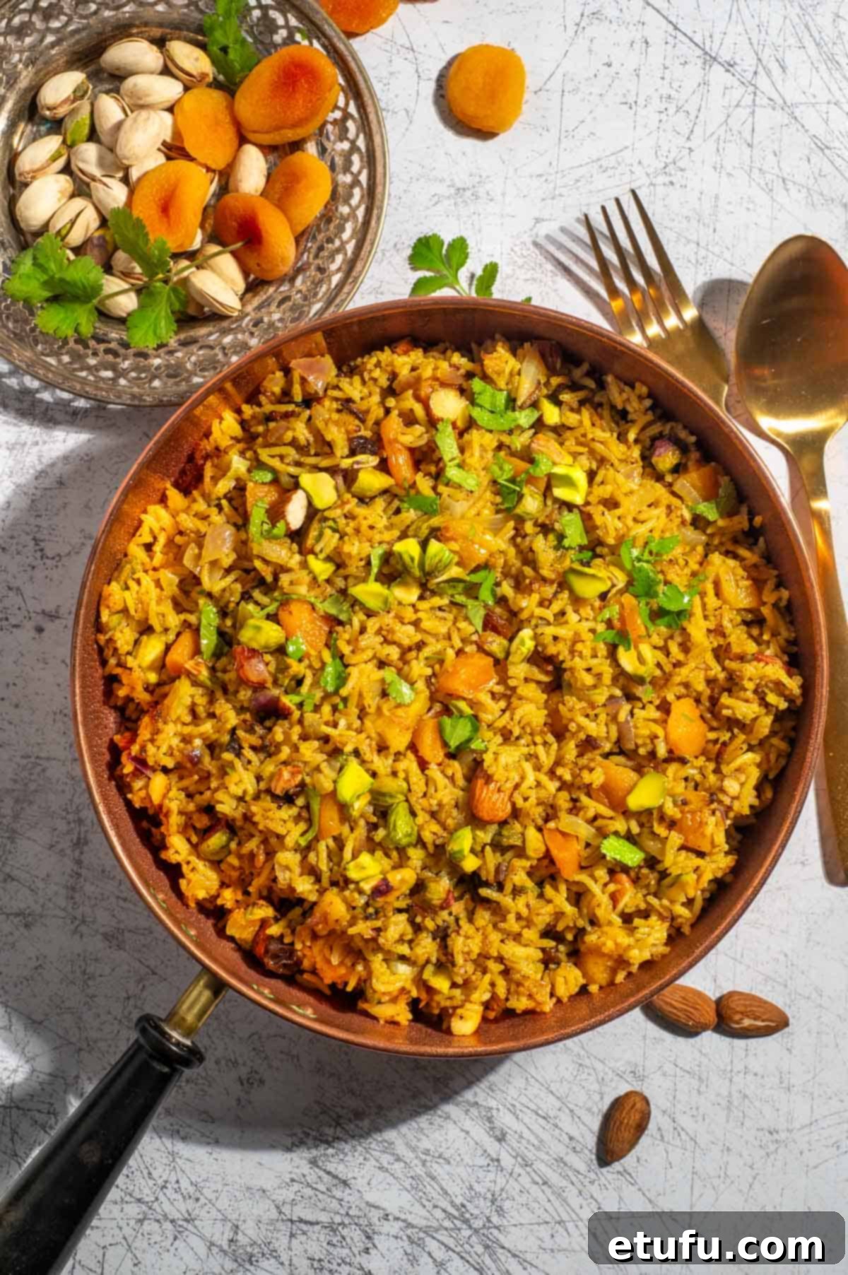 Sultan's Moroccan Pilaf 2 Glistening Moroccan rice pilaf in a traditional copper pan, garnished with herbs and nuts.