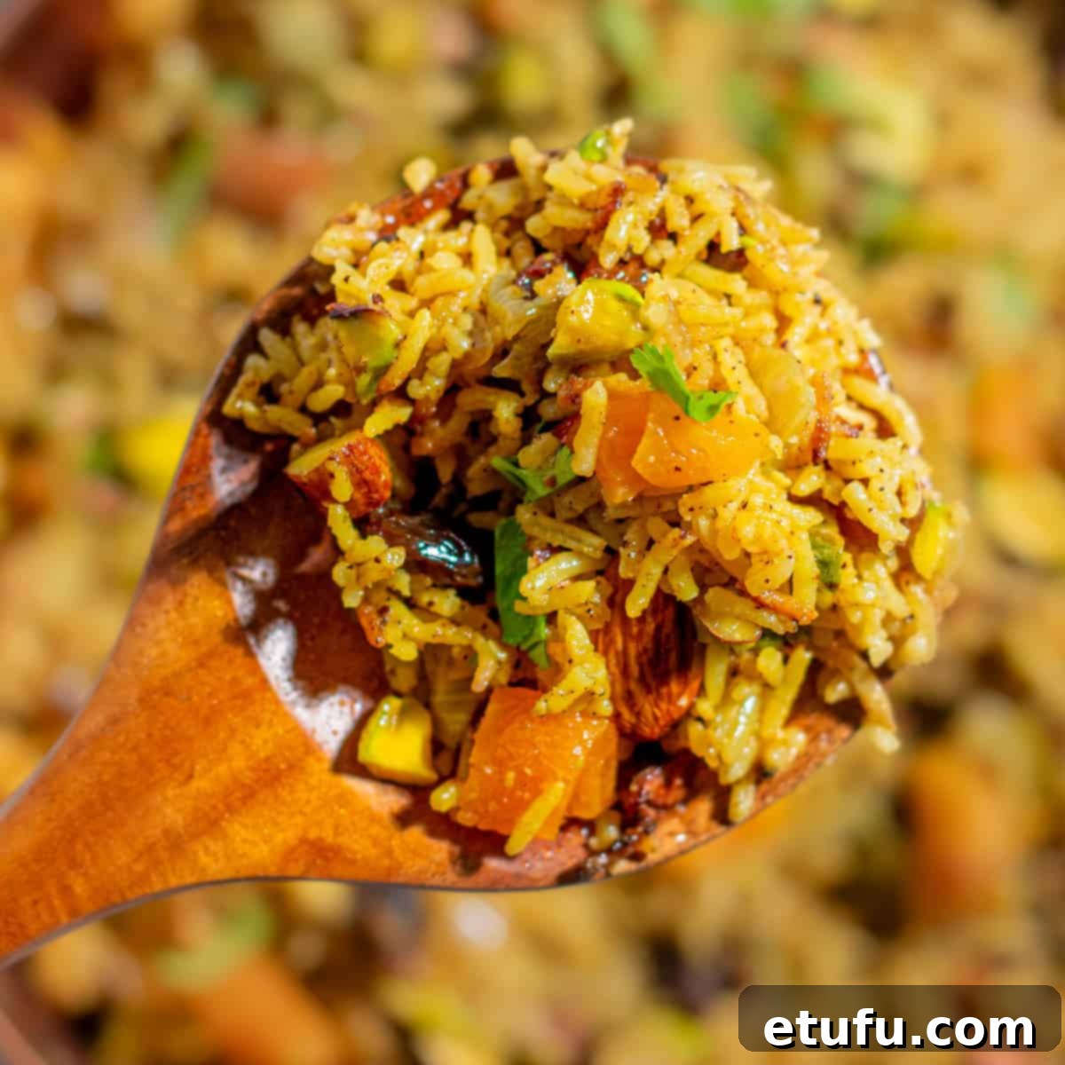 Sultan's Moroccan Pilaf 10 A close-up shot of a spoonful of Moroccan rice pilaf, showcasing its fluffy texture, vibrant dried fruits, and crunchy nuts.