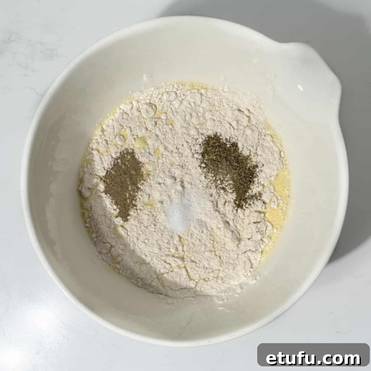 Adding self-raising flour, thyme, salt, and pepper to the egg and milk mixture in a bowl.