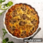 Bacon and mushroom quiche in a white tart dish.