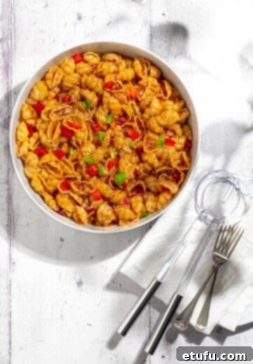 Curry noodle salad in a large white bowl, garnished with fresh herbs.