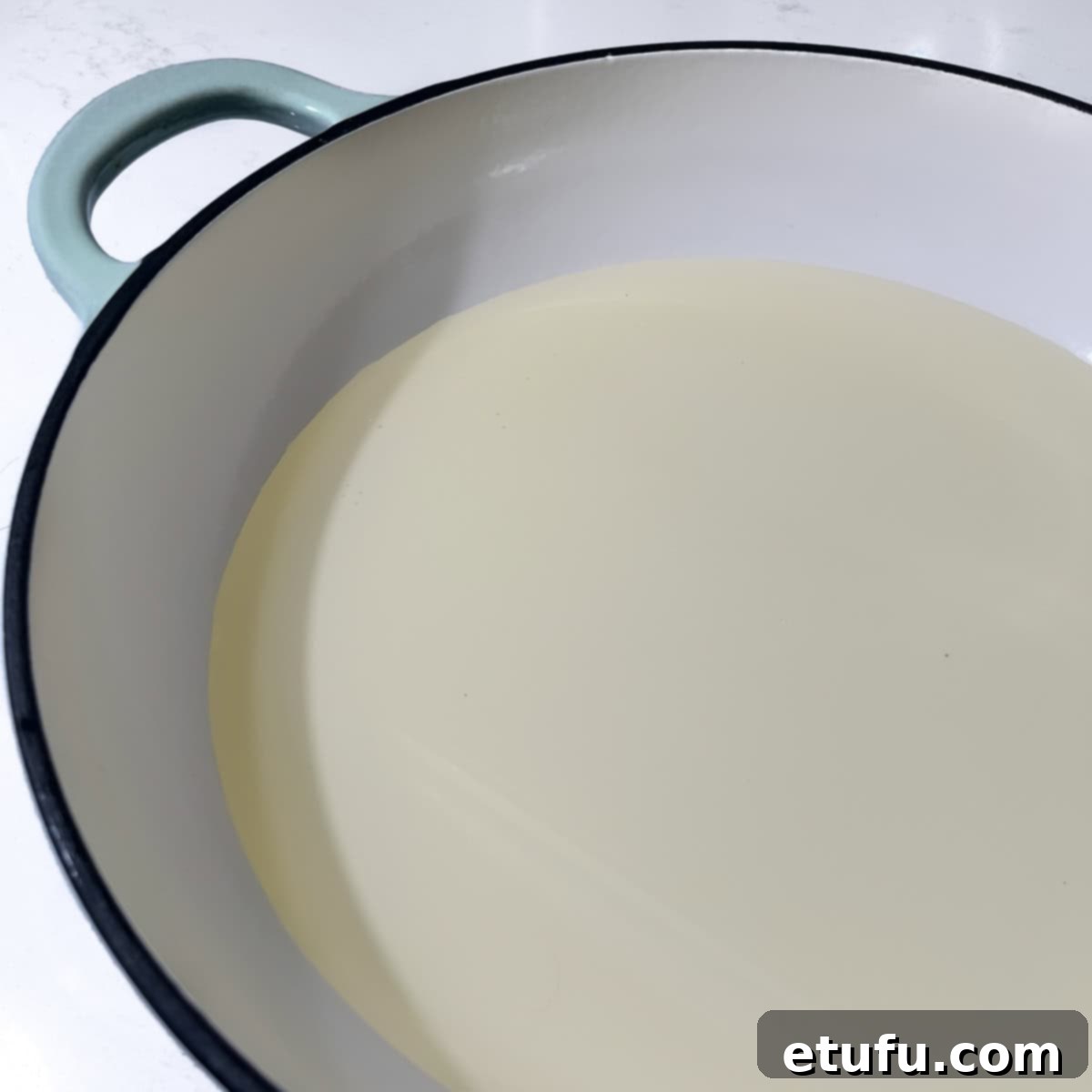 A large non-stick frying pan with about ½ inch (1½ cm) of oil, demonstrating the ideal depth for shallow-frying pumpkin fritters without deep-frying.