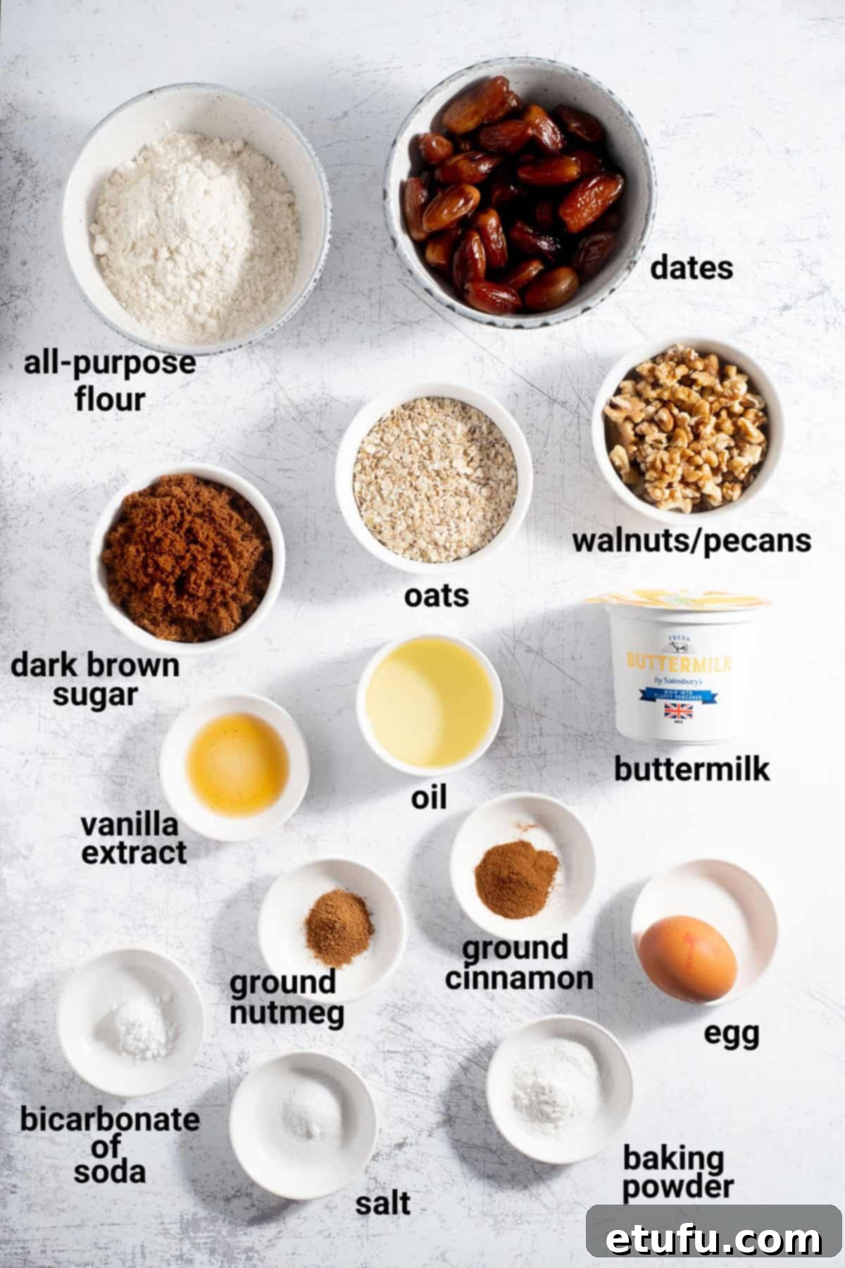 All the fresh ingredients required to make delicious date muffins laid out on a surface.