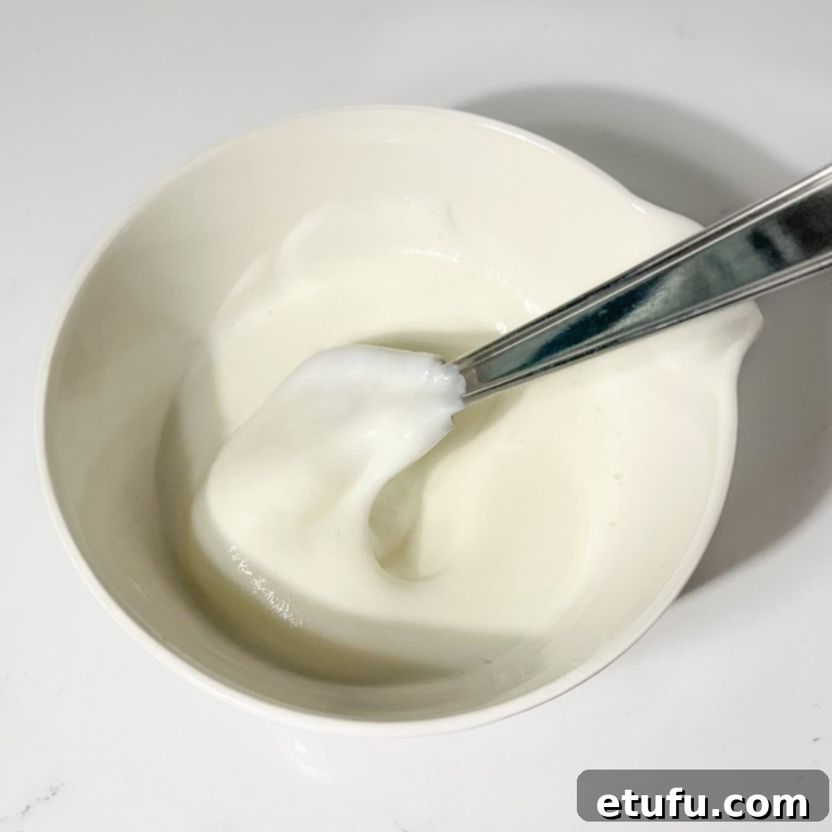 Whisking buttermilk and bicarbonate of soda together until foamy in a small bowl.