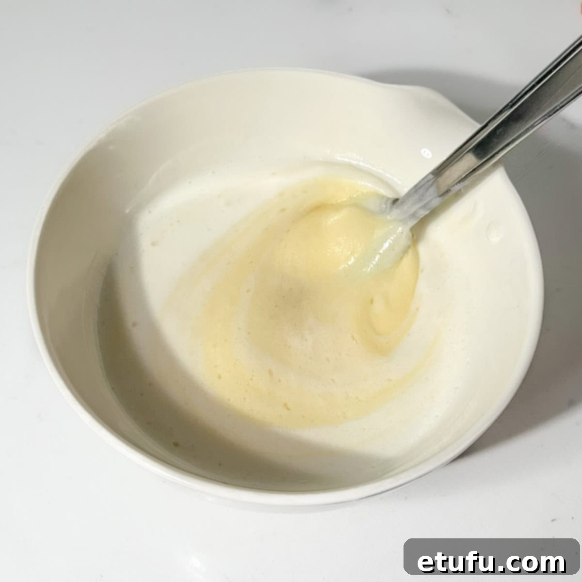 Whisking egg, vanilla, and oil into the buttermilk mixture for the muffin batter.