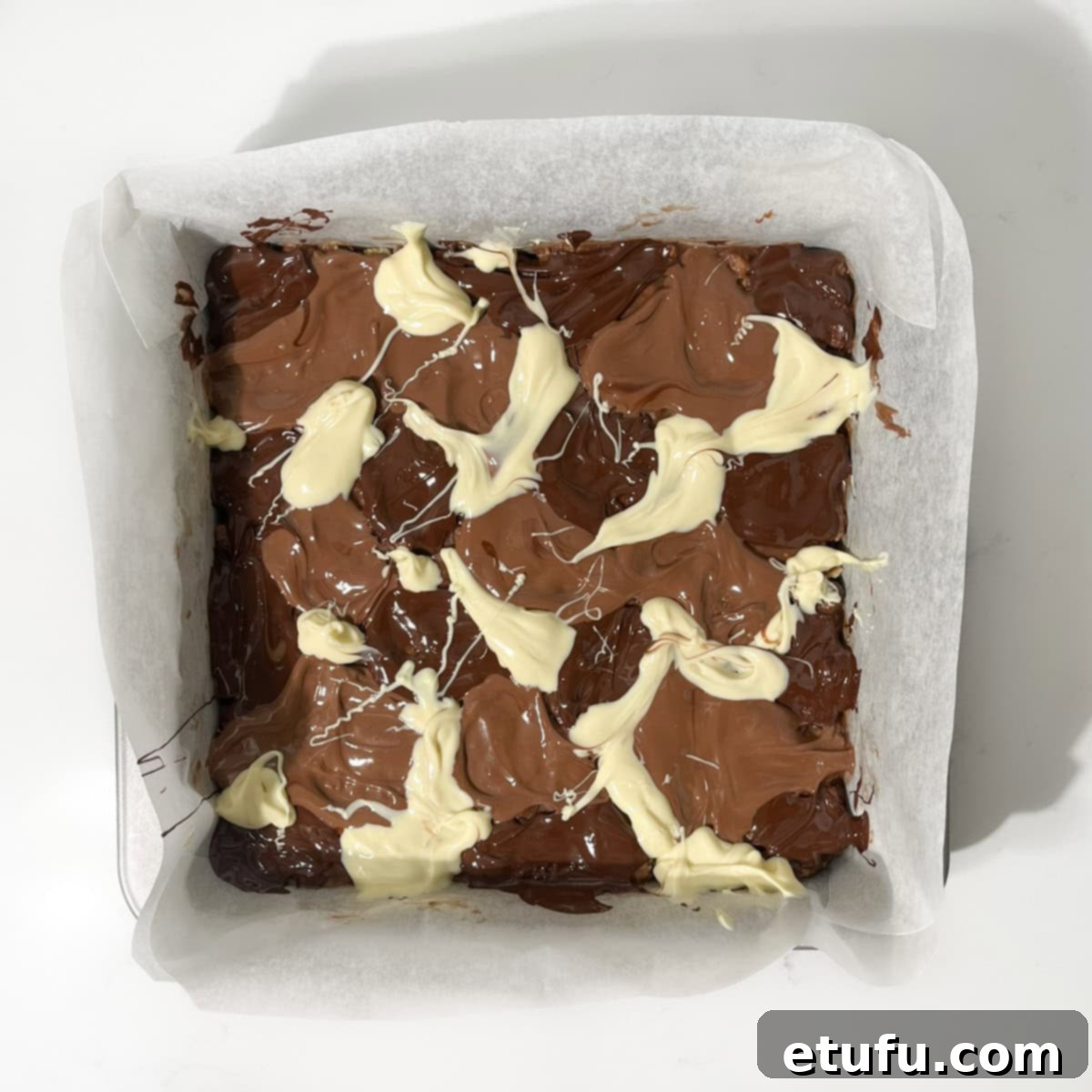 Decadent No-Bake Chocolate Biscuit Delight 11 Adding dollops of melted milk, dark, and white chocolate onto the chocolate biscuit cake's surface for marbling.