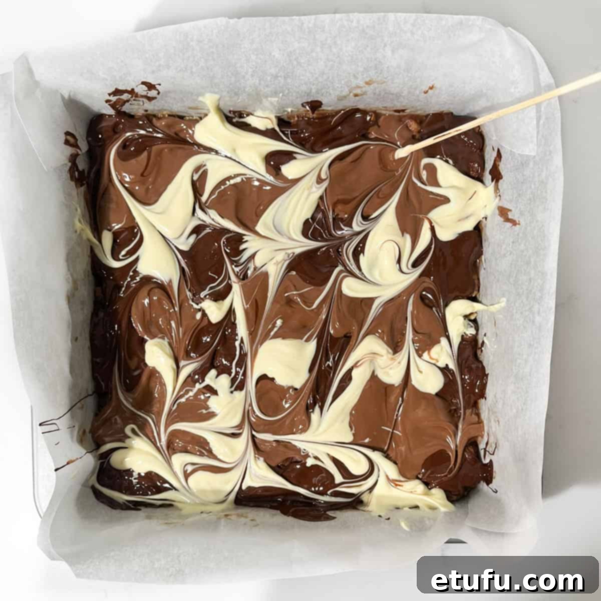 Decadent No-Bake Chocolate Biscuit Delight 12 Marbling three different chocolate colors on the chocolate refrigerator cake with a skewer.