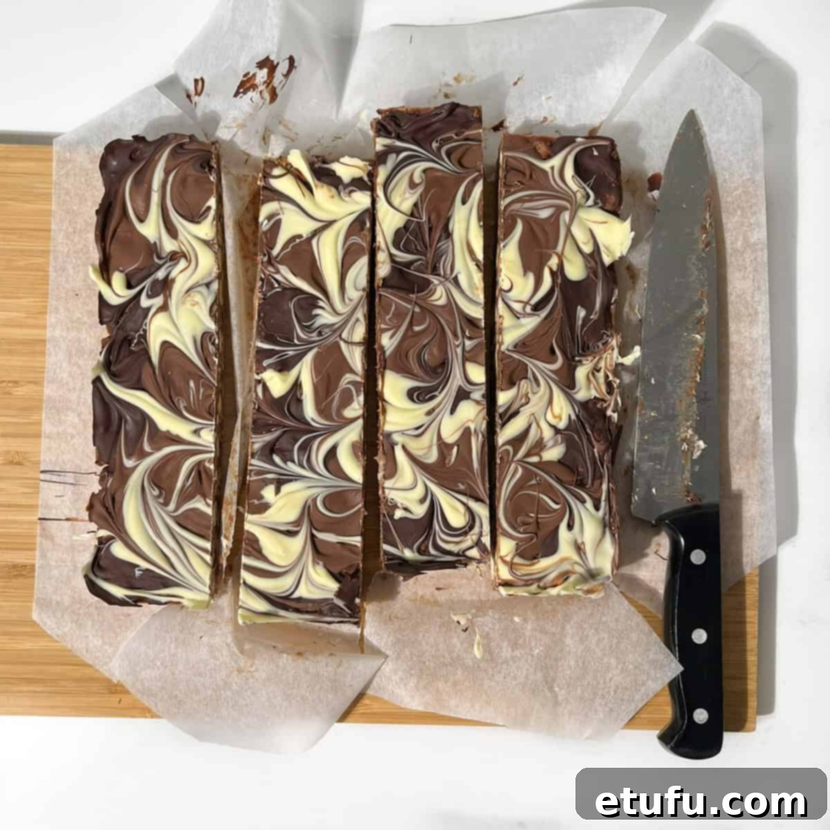Decadent No-Bake Chocolate Biscuit Delight 13 Slicing the chocolate biscuit cake into neat squares using a hot knife.