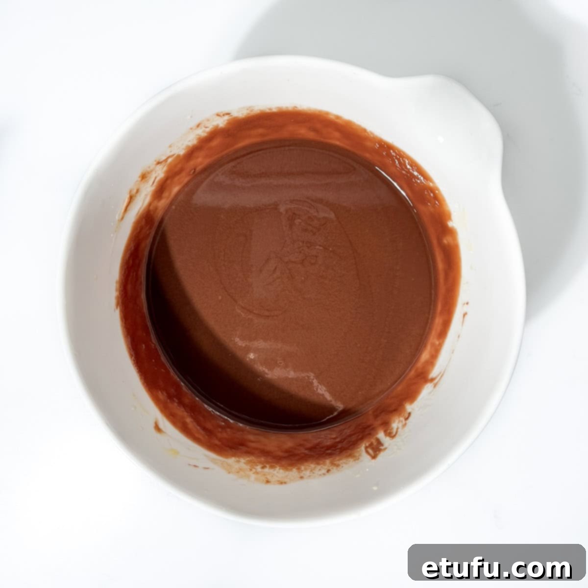 Decadent No-Bake Chocolate Biscuit Delight 6 Chocolate mixture cooling in a bowl after melting.